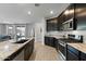 Spacious kitchen with dark cabinetry, granite island and stainless steel appliances at 17838 W Gambit Trl, Surprise, AZ 85387