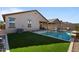 Modern rectangular pool with artificial turf and patio at 17838 W Gambit Trl, Surprise, AZ 85387