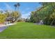 Large backyard with expansive lawn, mature trees, and flagstone patio at 245 W Berridge Ln, Phoenix, AZ 85013