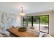 Bright dining room with wooden table, modern art, and view to backyard at 245 W Berridge Ln, Phoenix, AZ 85013