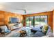 Stylish living room with wood paneling, comfortable seating, and backyard access at 245 W Berridge Ln, Phoenix, AZ 85013