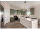 Modern kitchen with green cabinets and marble island at 2875 S 364Th Dr, Tonopah, AZ 85354