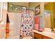 Well-lit bathroom featuring a shower and tub combination, decorative wallpaper, and a patterned shower curtain at 5028 S Peachwood Dr, Gilbert, AZ 85298