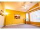 Bedroom with a large picture window, ceiling fan, and neutral colored carpet at 5028 S Peachwood Dr, Gilbert, AZ 85298