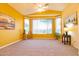 Bedroom with a large picture window, ceiling fan, and neutral colored carpet at 5028 S Peachwood Dr, Gilbert, AZ 85298