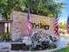Elegant community entrance featuring a stone sign, water feature, and American flags at 5028 S Peachwood Dr, Gilbert, AZ 85298