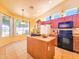 Eat in kitchen with tile floors, center island, oak cabinets and black appliances at 5028 S Peachwood Dr, Gilbert, AZ 85298