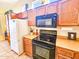 Close up on kitchen appliances including a black stove, oak cabinets, and microwave oven at 5028 S Peachwood Dr, Gilbert, AZ 85298