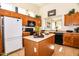 Well-equipped kitchen featuring wood cabinets, an island, and black appliances at 5028 S Peachwood Dr, Gilbert, AZ 85298