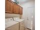 Functional laundry room equipped with washer, dryer, and storage cabinets at 5028 S Peachwood Dr, Gilbert, AZ 85298