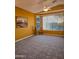 Bright living room featuring neutral carpet, large windows, and a ceiling fan at 5028 S Peachwood Dr, Gilbert, AZ 85298