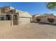 Tan two-story home with a three-car garage and a brick paved driveway at 6202 E Mckellips Rd # 91, Mesa, AZ 85215