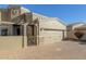 Tan two-story home with a three-car garage and a brick paved driveway at 6202 E Mckellips Rd # 91, Mesa, AZ 85215