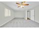 Bedroom with carpet, ceiling fan and adjacent bathroom access at 7357 W Canterbury Dr, Peoria, AZ 85345