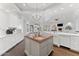 Modern kitchen with white cabinets, a statement chandelier, and an island with sink at 7635 E Poinsettia Dr, Scottsdale, AZ 85260