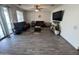 Spacious living room with gray flooring, brown couches, and a large TV at 10154 W Lawrence Ln, Peoria, AZ 85345