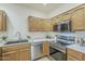 Bright kitchen featuring stainless steel appliances, modern faucet, and warm wood cabinetry at 11360 E Keats Ave # 78, Mesa, AZ 85209