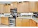 Bright kitchen with light wood cabinets, stainless steel appliances, and granite countertops at 11967 W Vernon Ave, Avondale, AZ 85392