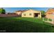 A large backyard with grass and view of the home and covered patio at 1844 S 238Th Ln, Buckeye, AZ 85326