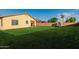 Spacious backyard with lush green grass, a charming playhouse, and a covered patio at 1844 S 238Th Ln, Buckeye, AZ 85326