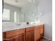 Bathroom with double vanity, wood cabinets, and a shower at 1844 S 238Th Ln, Buckeye, AZ 85326