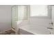 Clean bathroom with a tub and shower, and a window with blinds at 1844 S 238Th Ln, Buckeye, AZ 85326