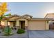 Tan exterior house with a two-car garage and desert landscaping at 1844 S 238Th Ln, Buckeye, AZ 85326