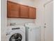 Laundry room with washer, dryer, and wooden cabinets at 1844 S 238Th Ln, Buckeye, AZ 85326