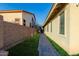 Paver walkway between the home and block wall with lush green grass at 1844 S 238Th Ln, Buckeye, AZ 85326
