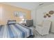 Cozy bedroom featuring a striped quilt, neutral walls, and a comfortable armchair at 18611 N 22Nd St # 2, Phoenix, AZ 85024