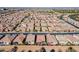 Expansive aerial view of a community boasting uniform homes, well-manicured lawns, and scenic golf course in the background at 267 E Santa Lucia Ln, Queen Creek, AZ 85140