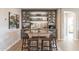 Stylish dining area with a glass table, four chairs, and a custom bar with built-in wine storage at 267 E Santa Lucia Ln, Queen Creek, AZ 85140