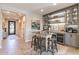 Stylish dining area with a glass table, four chairs, and a custom bar with built-in wine storage at 267 E Santa Lucia Ln, Queen Creek, AZ 85140