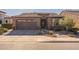Charming single-story home showcasing a paver driveway, a two-car garage, and desert landscaping at 267 E Santa Lucia Ln, Queen Creek, AZ 85140