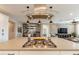 Kitchen island with gas range and modern vent hood, flowing into a living area with custom bar at 267 E Santa Lucia Ln, Queen Creek, AZ 85140