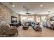 Spacious living room featuring a large sectional sofa, custom TV wall, and seamless flow to the dining area at 267 E Santa Lucia Ln, Queen Creek, AZ 85140