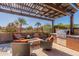 Inviting outdoor living space with covered patio, built-in BBQ, comfortable seating, and a stone fire pit at 267 E Santa Lucia Ln, Queen Creek, AZ 85140