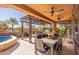 Spacious covered patio with ceiling fans, a dining table, a built-in BBQ, and comfortable lounge seating at 267 E Santa Lucia Ln, Queen Creek, AZ 85140