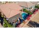 Aerial view of a private backyard pool and patio area, surrounded by desert landscaping, mature trees, and red-tiled roof at 267 E Santa Lucia Ln, Queen Creek, AZ 85140