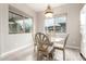 Bright breakfast nook with glass table and vintage style chairs, with backyard views from multiple windows at 2827 E Bellerive Dr, Gilbert, AZ 85298