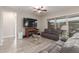 Spacious living room boasts a fireplace, TV, and large windows, with a gray leather sofa at 2827 E Bellerive Dr, Gilbert, AZ 85298
