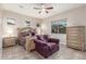 This main bedroom offers a beautiful bed frame, fan, tile floors, and comfortable sitting area at 2827 E Bellerive Dr, Gilbert, AZ 85298