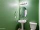 Small bathroom with pedestal sink, toilet and oval mirror at 2832 E Flower St, Gilbert, AZ 85298