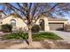 Single-story home with tan exterior, arched entryway, and landscaped yard at 2832 E Flower St, Gilbert, AZ 85298