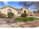 One-story house with a tan stucco exterior, arched entryway, and well-maintained landscaping at 2832 E Flower St, Gilbert, AZ 85298
