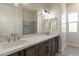 Modern bathroom featuring double sinks, dark wood cabinets, and a large mirror at 30039 N 209Th Ave, Wittmann, AZ 85361