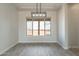 Bright dining room featuring modern light fixture, large window and wood-look tile floors at 30039 N 209Th Ave, Wittmann, AZ 85361