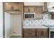 Well-equipped kitchen features stainless steel appliances, patterned backsplash, and custom cabinets at 30039 N 209Th Ave, Wittmann, AZ 85361