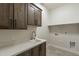 Bright laundry room with stylish cabinets, quartz countertops and a utility sink at 30039 N 209Th Ave, Wittmann, AZ 85361
