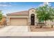 One-story house with tan exterior, two-car garage, and landscaped front yard at 41356 W Jenna Ln, Maricopa, AZ 85138